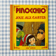 Livre Pinocchio joue aux cartes
